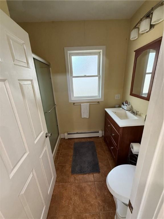 full bathroom featuring a healthy amount of sunlight, tile patterned flooring, a baseboard radiator, and a stall shower