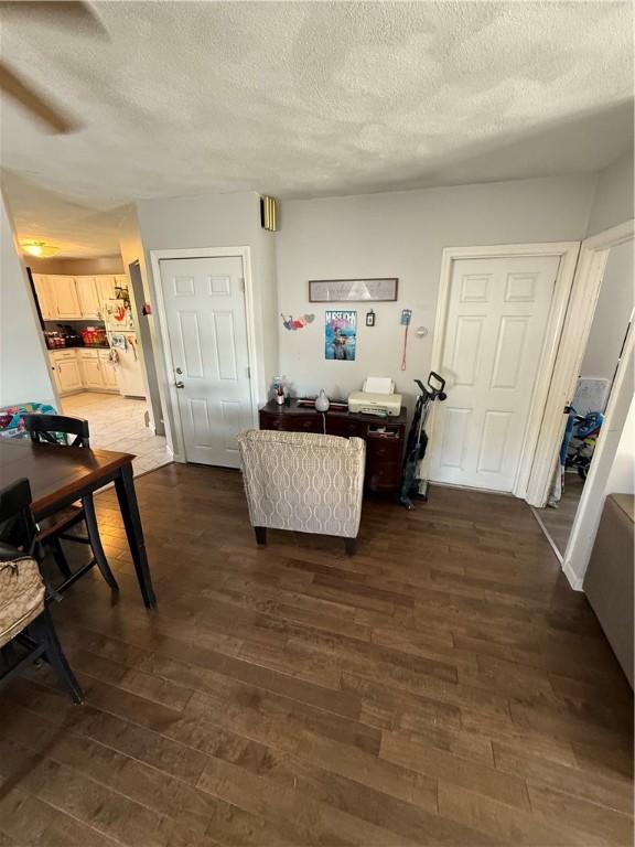 interior space featuring a textured ceiling and dark wood-type flooring