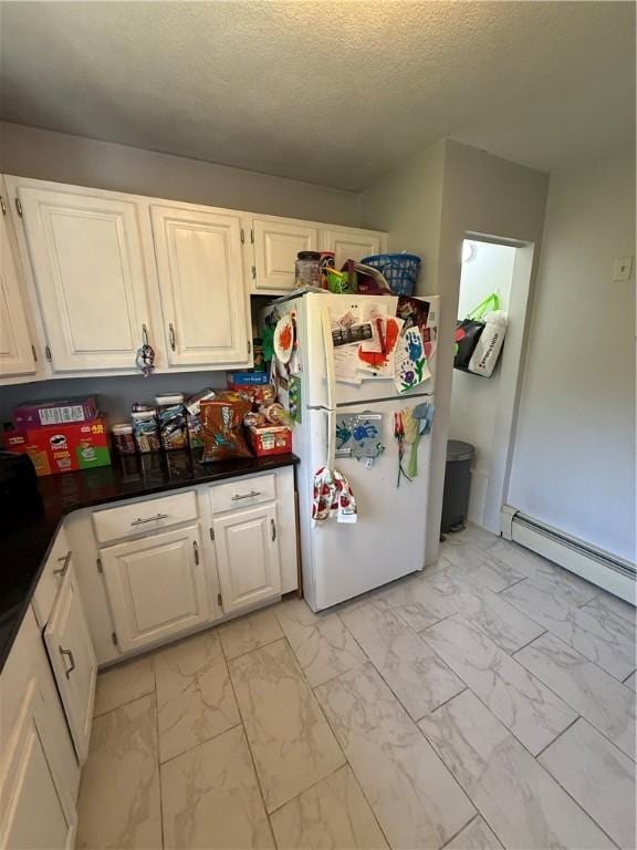 kitchen with freestanding refrigerator, white cabinetry, and marble finish floor