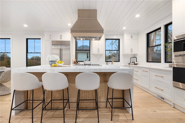 7 Champlin St, Newport, RI 02840 - kitchen featuring premium range hood, a center island, stainless steel appliances, white cabinetry, and wood ceiling
