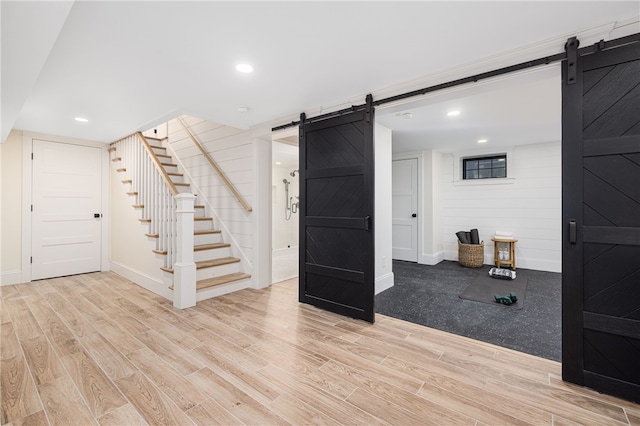 7 Champlin St, Newport, RI 02840 - below grade area with baseboards, stairs, a barn door, and wood finished floors