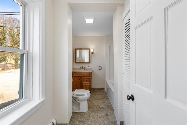 full bath with vanity, baseboards, a bathtub, and toilet