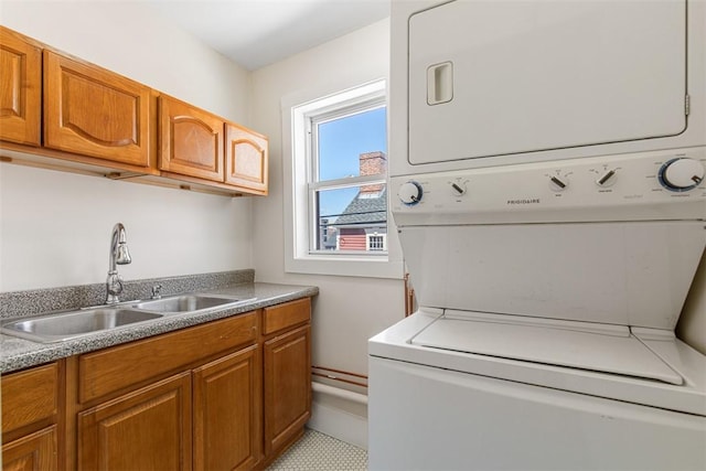 washroom with a sink, cabinet space, and stacked washer / dryer