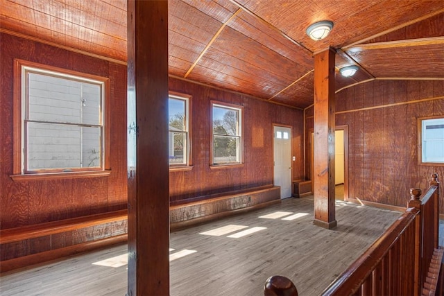 interior space with wooden walls, wood ceiling, wood finished floors, and lofted ceiling