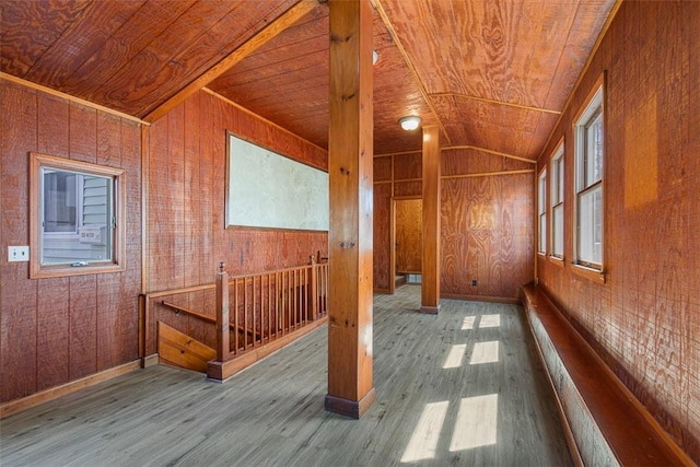 interior space with wooden ceiling, wood walls, wood finished floors, and lofted ceiling