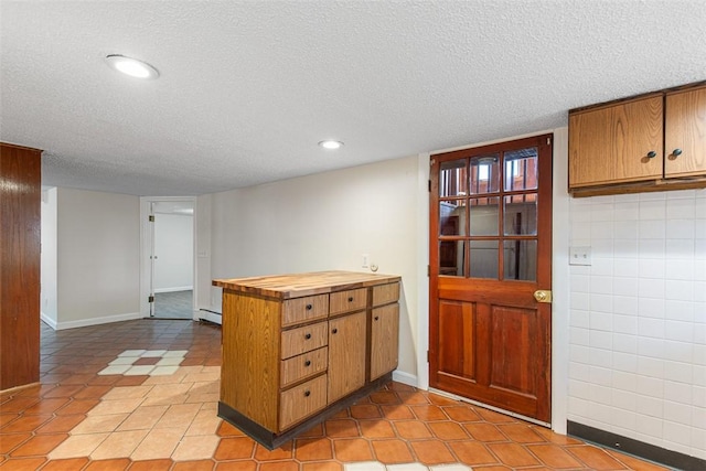 kitchen with recessed lighting, brown cabinetry, a textured ceiling, and a peninsula