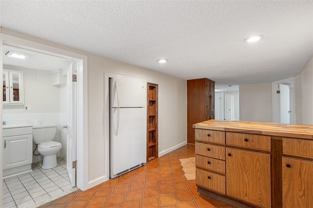bathroom with tile patterned flooring, vanity, toilet, recessed lighting, and a textured ceiling