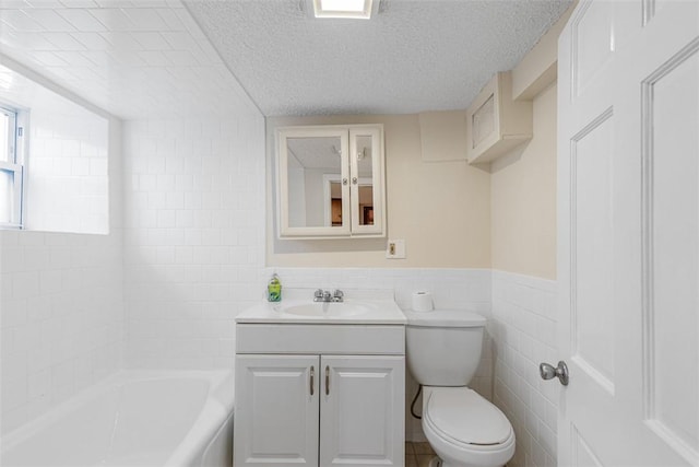 full bath with a textured ceiling, tile walls, wainscoting, vanity, and toilet