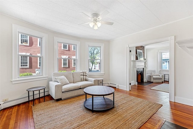 living room featuring a ceiling fan, a fireplace, a healthy amount of sunlight, and hardwood / wood-style floors