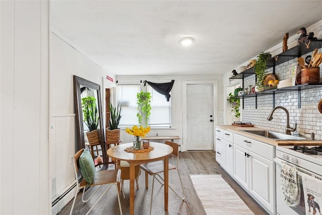 67 Pleasant St, Westerly, RI 02891 - kitchen featuring open shelves, a sink, white cabinetry, wood finished floors, and a baseboard radiator