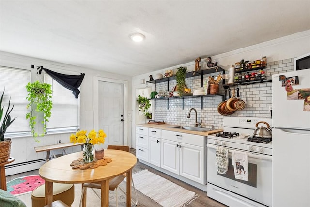 67 Pleasant St, Westerly, RI 02891 - kitchen featuring open shelves, baseboard heating, a sink, white appliances, and decorative backsplash
