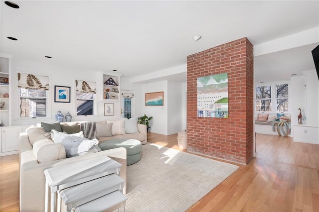 living area featuring light wood-type flooring and built in features