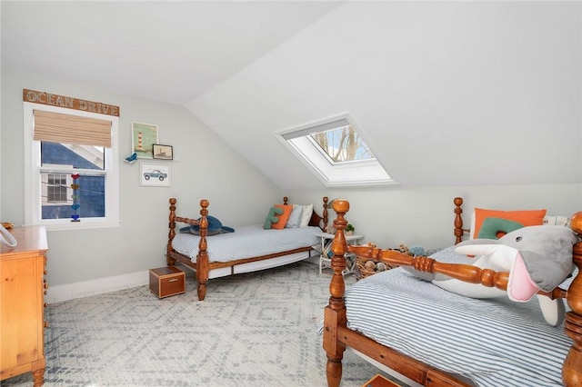 bedroom featuring vaulted ceiling with skylight, baseboards, and carpet