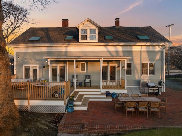rear view of house with french doors and a chimney