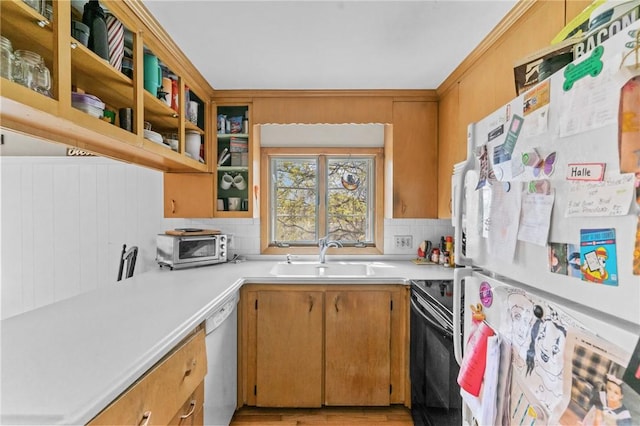 kitchen with tasteful backsplash, a sink, light countertops, glass insert cabinets, and white appliances