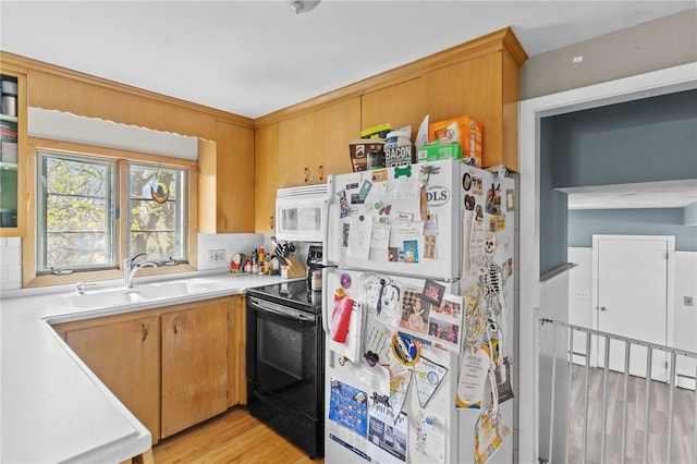 kitchen featuring light wood-type flooring, a sink, white appliances, and light countertops