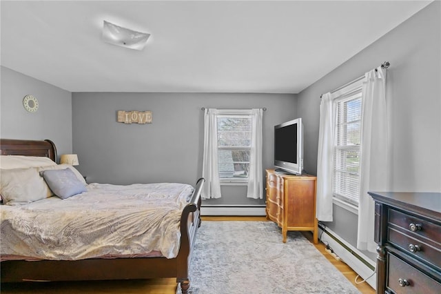 bedroom featuring light wood-style floors and baseboard heating