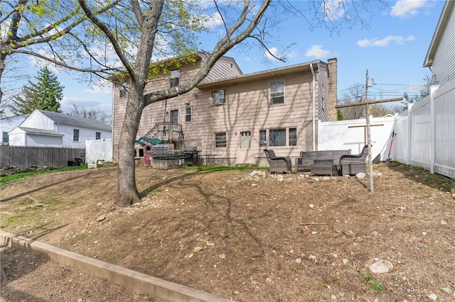 rear view of property featuring a fenced backyard and an outdoor living space