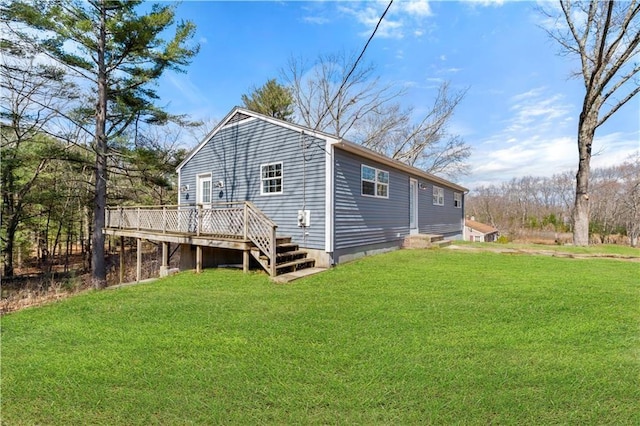 rear view of property featuring a lawn and a wooden deck