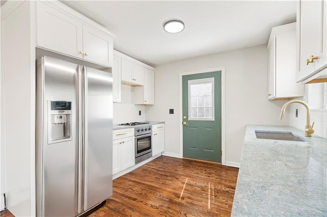 kitchen with a sink, white cabinets, stainless steel appliances, and dark wood-style flooring