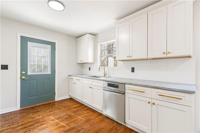 kitchen with baseboards, dark wood-type flooring, white cabinets, tasteful backsplash, and a sink