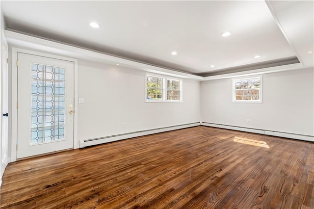 below grade area with recessed lighting, a baseboard radiator, wood finished floors, and a wealth of natural light