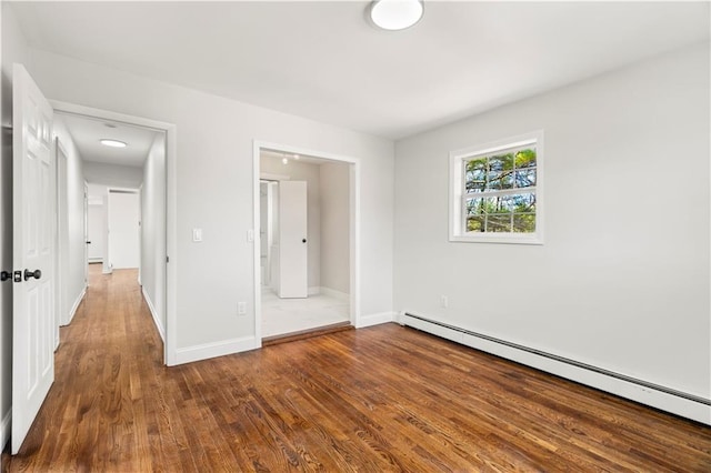 unfurnished bedroom featuring baseboards, baseboard heating, and wood finished floors