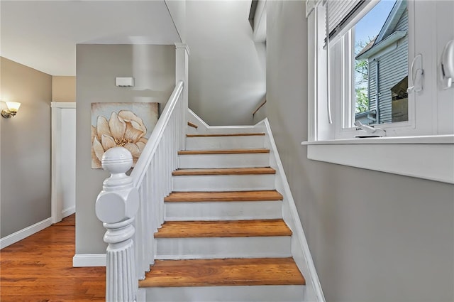 stairway featuring baseboards and wood finished floors