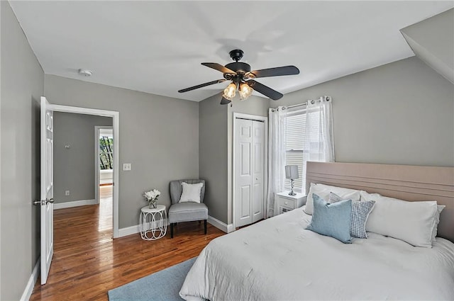 bedroom featuring baseboards, ceiling fan, wood finished floors, and a closet