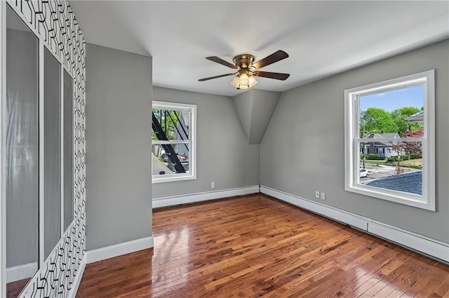 additional living space featuring lofted ceiling, baseboards, ceiling fan, hardwood / wood-style flooring, and a baseboard radiator