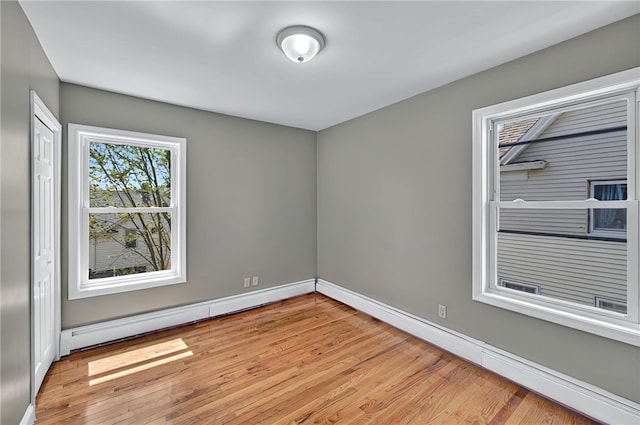 unfurnished room featuring baseboards and light wood-type flooring