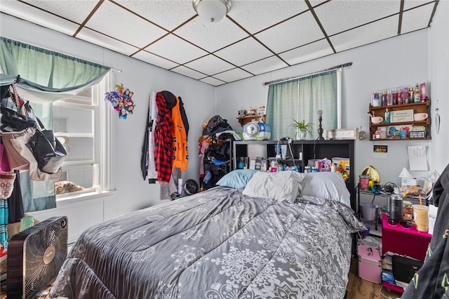 bedroom featuring wood finished floors and a drop ceiling