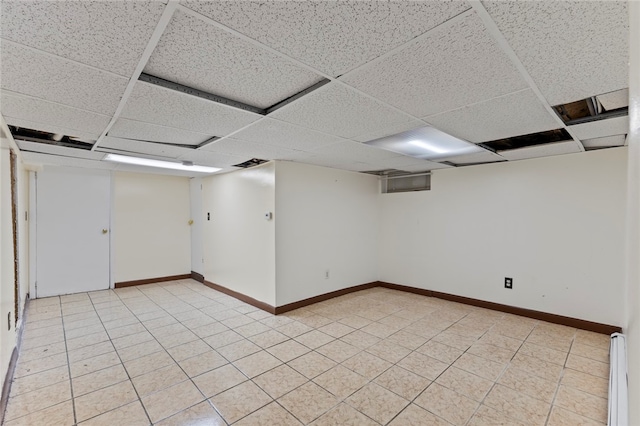finished below grade area featuring baseboards and a paneled ceiling