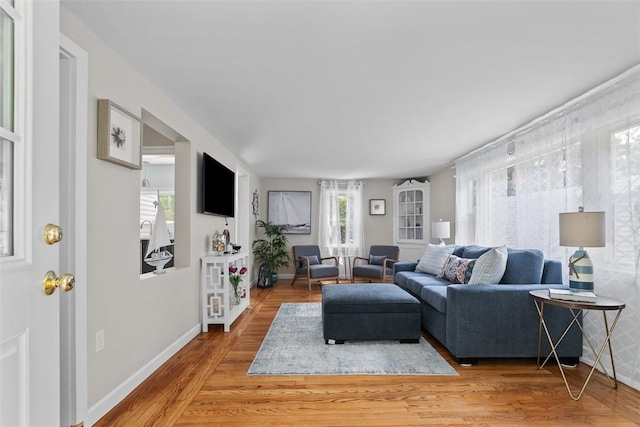 living room with baseboards and light wood-style flooring