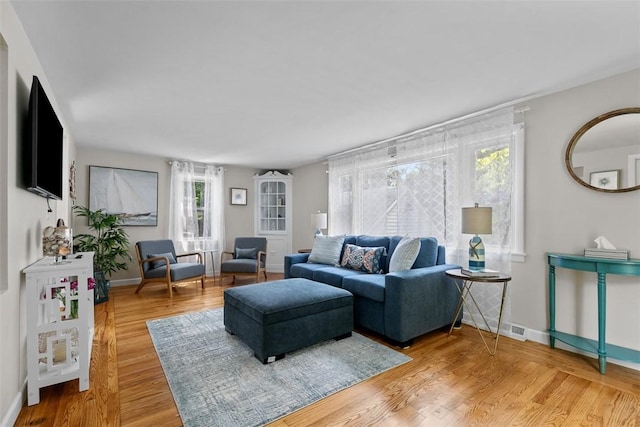 living area featuring light wood-style floors and baseboards