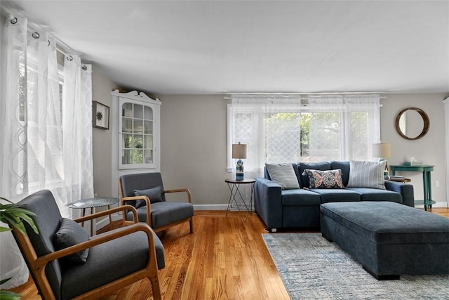 living area with baseboards and light wood finished floors