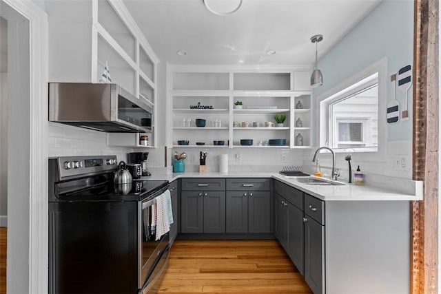 kitchen with open shelves, appliances with stainless steel finishes, a sink, decorative backsplash, and gray cabinetry