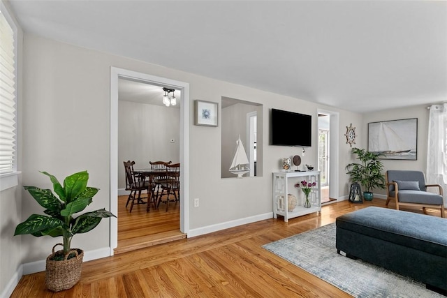 living room featuring a healthy amount of sunlight, baseboards, and light wood-type flooring