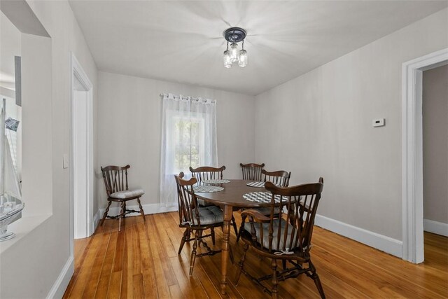 dining space with baseboards and light wood finished floors