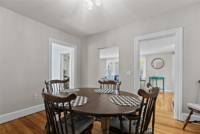 dining area with baseboards and light wood-type flooring