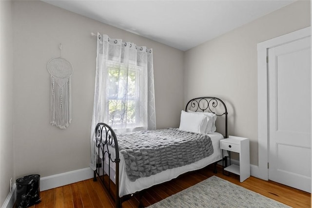 bedroom featuring baseboards and wood finished floors