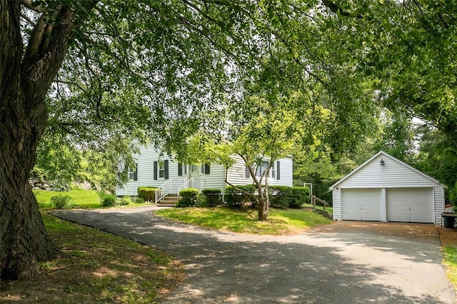 view of front of house featuring a garage and an outbuilding