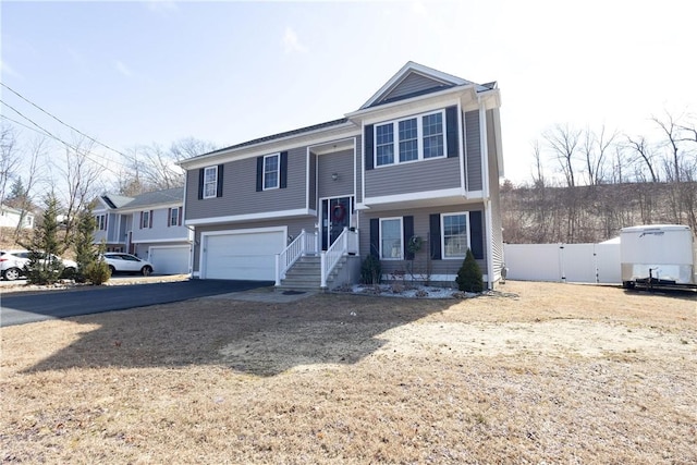 32 Dike St, Woonsocket, RI 02895 - split foyer home featuring a garage, aphalt driveway, and fence