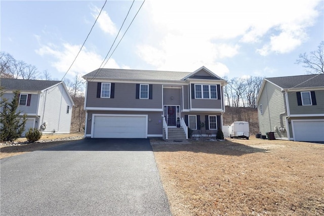 32 Dike St, Woonsocket, RI 02895 - split foyer home featuring an attached garage and driveway