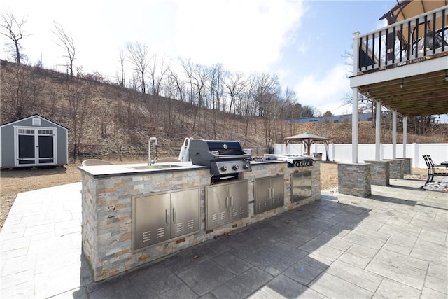 32 Dike St, Woonsocket, RI 02895 - view of patio / terrace with a sink, a fenced backyard, a shed, an outdoor kitchen, and a grill