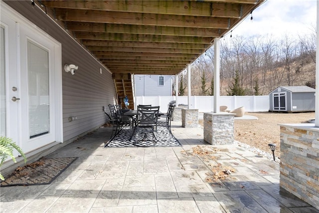 32 Dike St, Woonsocket, RI 02895 - view of patio with a fenced backyard, an outbuilding, a storage shed, and outdoor dining space