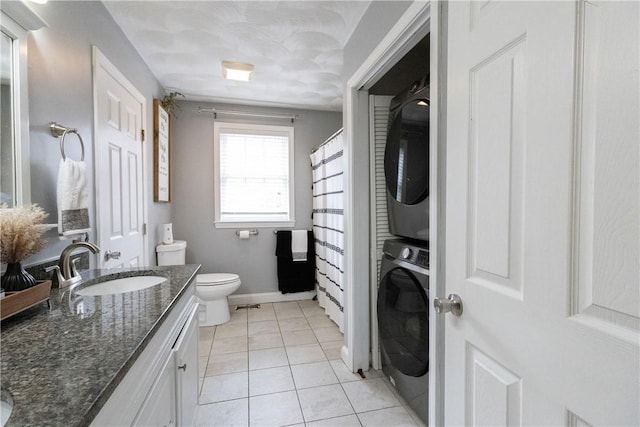 32 Dike St, Woonsocket, RI 02895 - full bathroom featuring vanity, tile patterned flooring, toilet, baseboards, and stacked washing maching and dryer