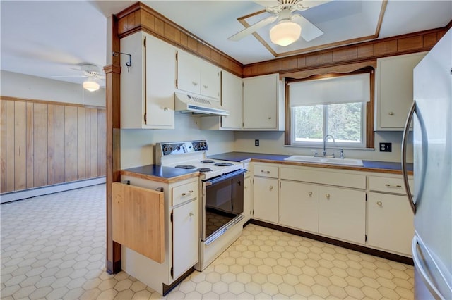 kitchen featuring a ceiling fan, white appliances, wooden walls, under cabinet range hood, and a sink