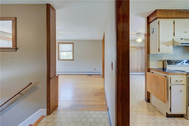 hall featuring baseboards and an upstairs landing