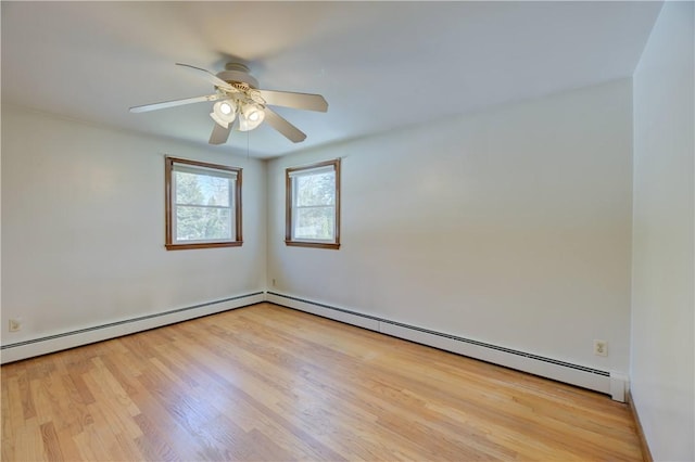 spare room with ceiling fan, a baseboard heating unit, and wood finished floors